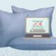 Graphic illustration of a laptop positioned on top of a pillow and surrounded by pillows